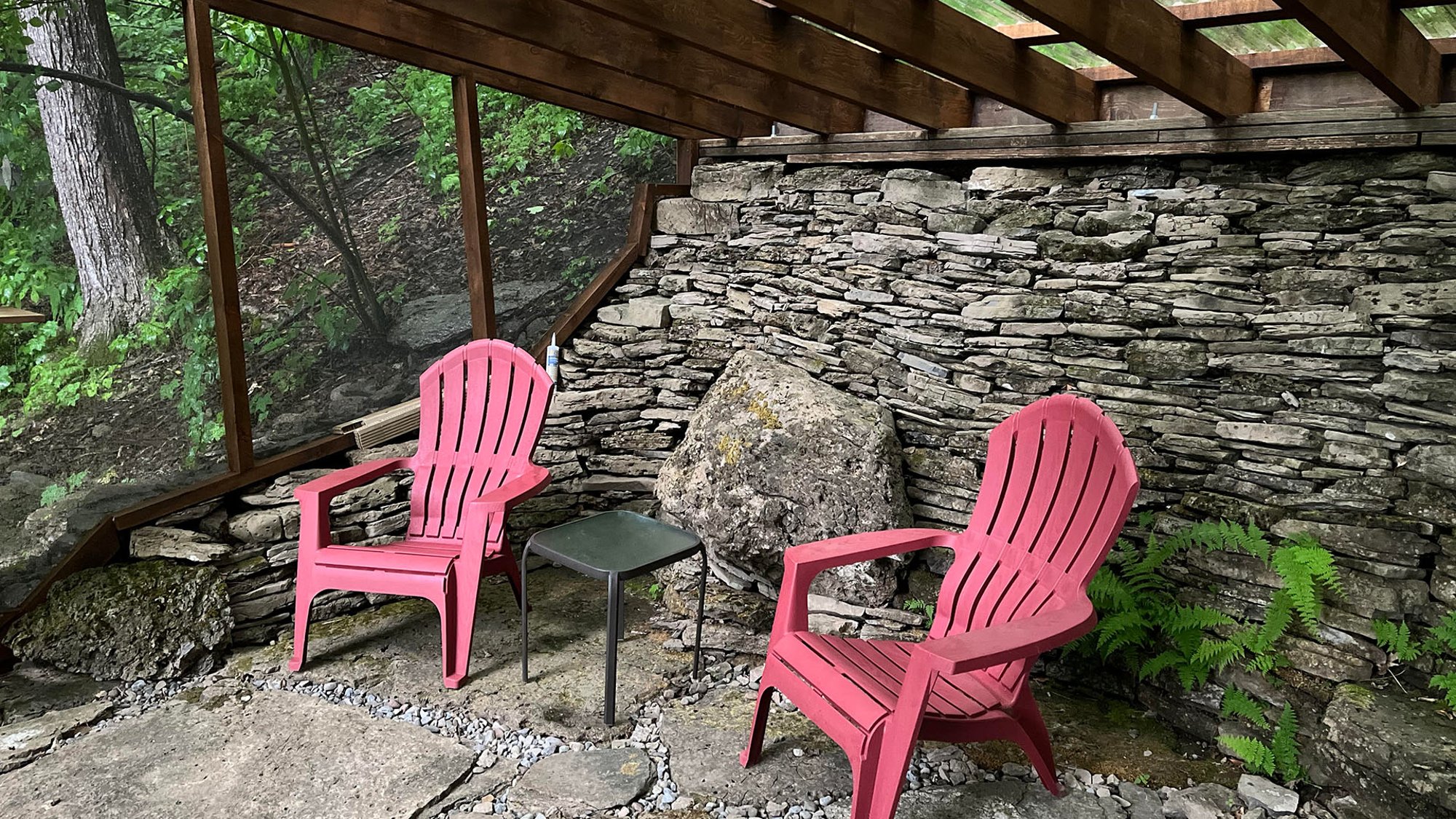 Two Adirondack chairs on a rock patio